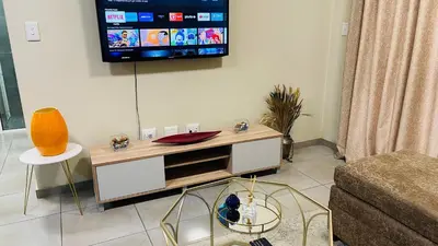 a living room with a tv on the wall at Mall Of Africa Spot3 By Damo in Midrand
