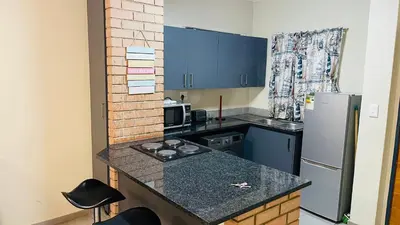 a small kitchen with a counter and a refrigerator at Mall Of Africa Spot3 By Damo in Midrand