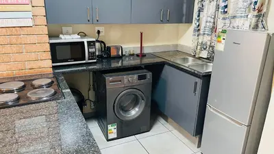 a kitchen with a washing machine and a microwave at Mall Of Africa Spot3 By Damo in Midrand
