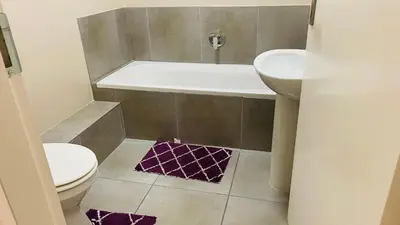 a bathroom with a toilet and a tub and a sink at Mall Of Africa Spot3 By Damo in Midrand