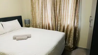 a white bed with a towel on top of it at Mall Of Africa Spot3 By Damo in Midrand