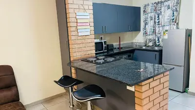 a small kitchen with a counter and a refrigerator at Mall Of Africa Spot3 By Damo in Midrand