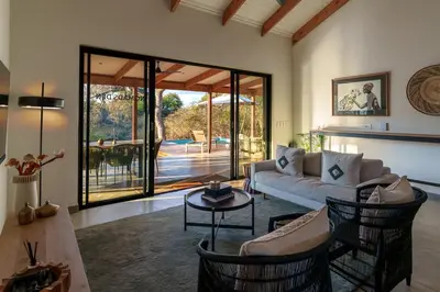 a living room with a couch and a table at Nomads Den Safari Villas - Heated Pools and Riverbed views in Hoedspruit
