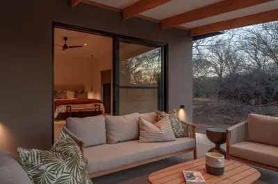a living room with a couch and a table at Nomads Den Safari Villas - Heated Pools and Riverbed views in Hoedspruit