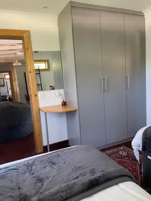 a bedroom with a bed and a desk and a cupboard at Idlewood unit 2 in Dullstroom