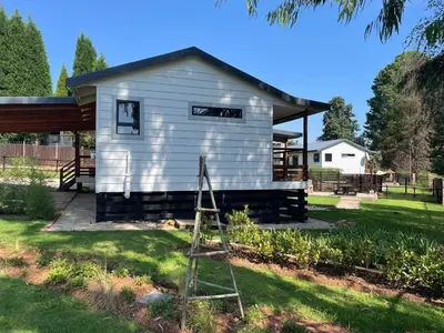 a small white building with a ladder in the yard at Idlewood unit 2 in Dullstroom
