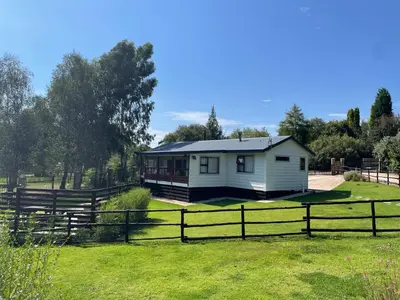 a white house in a field with a fence at Idlewood unit 2 in Dullstroom