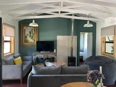 a living room with two couches and a tv at Idlewood unit 2 in Dullstroom