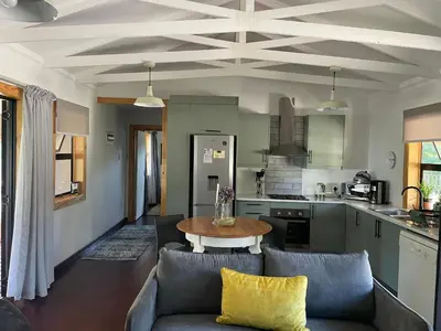 a living room with a couch and a table in a kitchen at Idlewood unit 2 in Dullstroom
