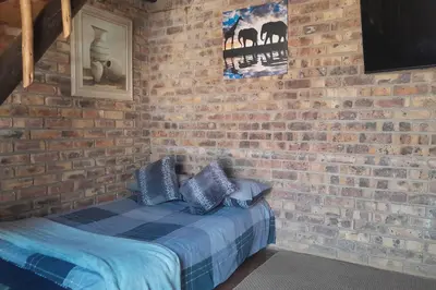 a brick wall with a bed in a room at Bushveld Bliss in Marloth Park