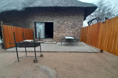a brick building with a table and a fence at Bushveld Bliss in Marloth Park