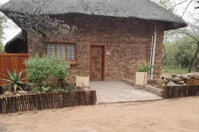 a small brick house with a thatched roof at Bushveld Bliss in Marloth Park