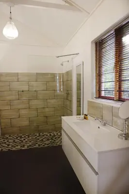 a white bathroom with a sink and a mirror at Almar View Guest House in Nelspruit