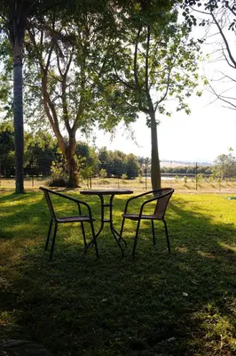 a picnic table and two benches in a park at Almar View Guest House in Nelspruit