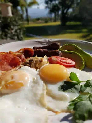 a plate of food with eggs and sausage and peppers at Almar View Guest House in Nelspruit