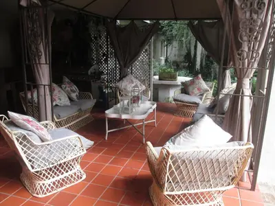 an outdoor patio with wicker chairs and a table at Almar View Guest House in Nelspruit