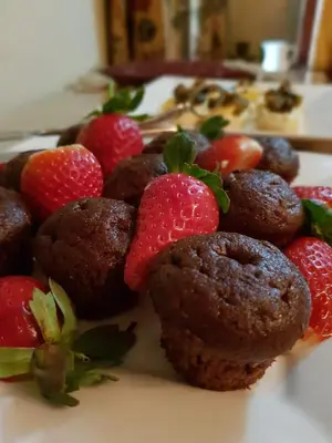 a plate of chocolate muffins with strawberries on it at Almar View Guest House in Nelspruit