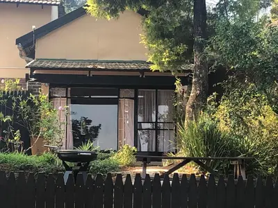 a black fence in front of a house with a grill at Cheerio Trout Fishing & Holiday Resort in Haenertsburg