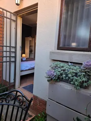 a window with purple flowers in a planter next to a bench at Cozy City Studio Escape in Centurion