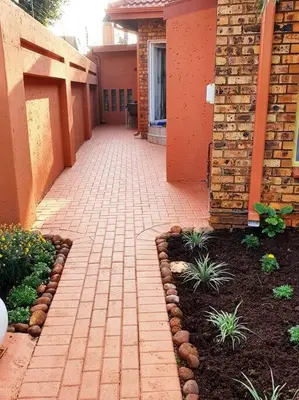 a brick walkway in front of a building with plants at CozyatCaley - Private Apartment in Centurion
