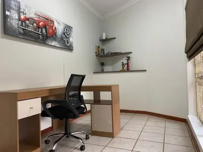 a office with a desk and a black chair at CozyatCaley - Private Apartment in Centurion