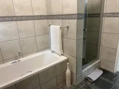 a bathroom with a bath tub and a shower at CozyatCaley - Private Apartment in Centurion