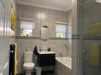 a bathroom with a toilet and a sink and a tub at CozyatCaley - Private Apartment in Centurion