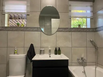 a bathroom with a sink and a toilet and a mirror at CozyatCaley - Private Apartment in Centurion