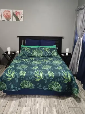 a bedroom with a bed with a blue comforter at Protea guest house in Pretoria