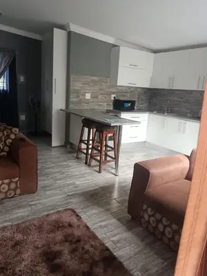 a kitchen with a couch and a table in a room at Protea guest house in Pretoria