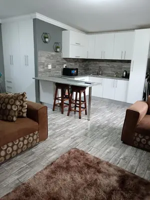 a kitchen and living room with a table and chairs at Protea guest house in Pretoria