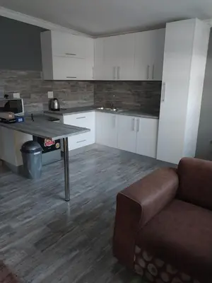 a kitchen with a table and a couch in a room at Protea guest house in Pretoria
