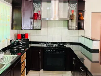 a kitchen with a black stove top oven at Khubonye Royal Guesthouse in Randjesfontein
