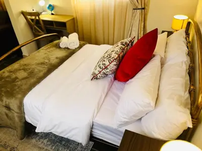 a bed with pillows on it in a room at Khubonye Royal Guesthouse in Randjesfontein