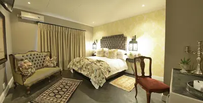 a bedroom with a bed and a chair at Duke & Duchess Boutique Hotel in Pretoria