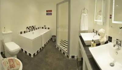 a bathroom with a tub and a toilet and a sink at Duke & Duchess Boutique Hotel in Pretoria