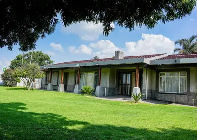 a house with a green lawn in front of it at SAR GUESTHOUSE in Benoni