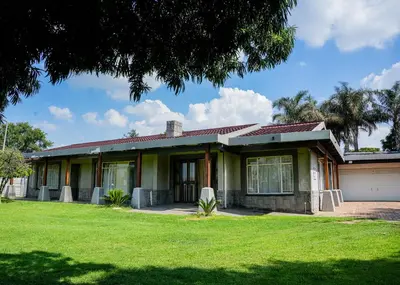 a house with a green lawn in front of it at SAR GUESTHOUSE in Benoni
