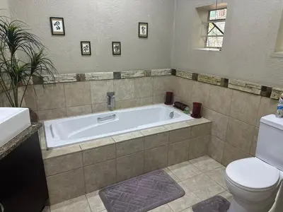 a bathroom with a tub and a toilet at Safari Bed & Breakfast in Hazyview