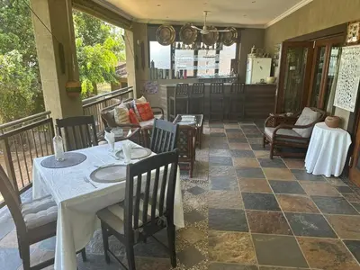 a restaurant with a table and chairs on a balcony at Safari Bed & Breakfast in Hazyview