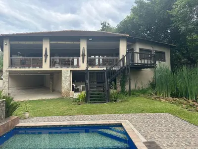 a house with a swimming pool in front of it at Safari Bed & Breakfast in Hazyview