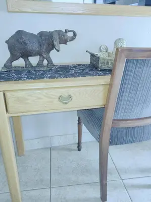 a wooden elephant figurine on a desk with a chair at ChoosersExpressHotel in Centurion