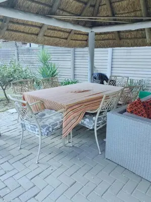 a table and chairs under an umbrella on a patio at ChoosersExpressHotel in Centurion