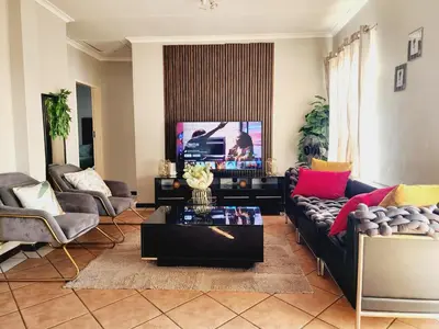 a living room with a couch and a tv at Fern Valley in Pretoria