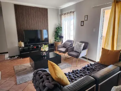 a living room with a couch and a television at Fern Valley in Pretoria