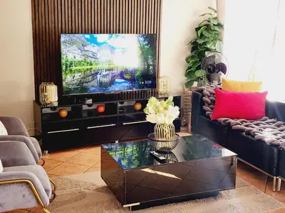 a living room with a couch and a tv at Fern Valley in Pretoria