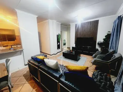 a living room with a couch and a television at Fern Valley in Pretoria