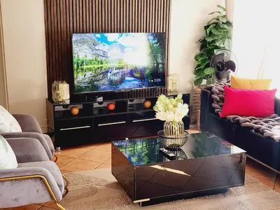 a living room with a tv and a coffee table at Fern Valley in Pretoria