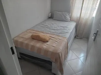 a small bedroom with a small bed with a blanket on it at Las Palmas Day & Night Guest House in Pretoria