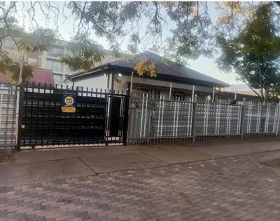a building with a gate and a fence at Las Palmas Day & Night Guest House in Pretoria